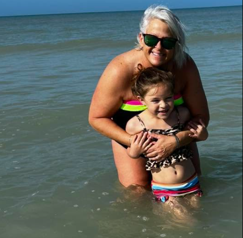 Alisha “G” James with a swimmer at the beach